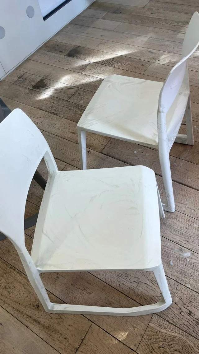White chairs with visible smears on their seats and backs before cleaning.