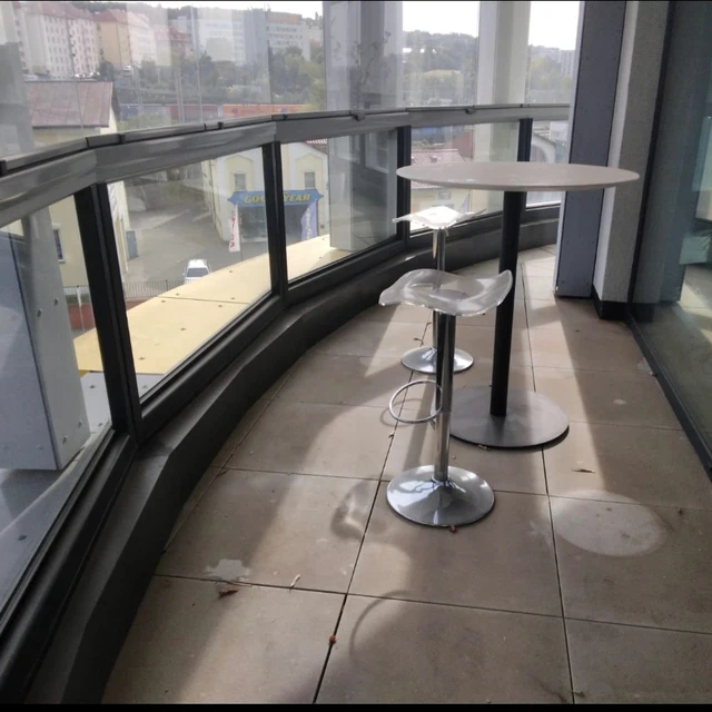The tiled floor of a glazed loggia with dirt and marks beneath the furniture before cleaning.